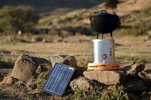 Solar-powered cooking stove with solar panel and outdoor setting.